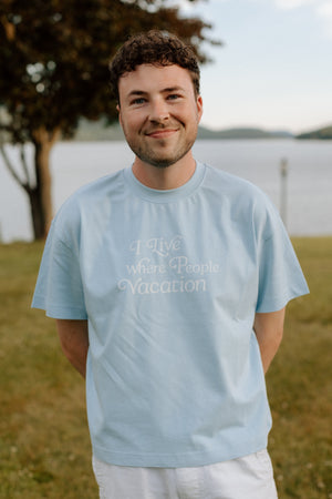 I Live Where People Vacation – Core Tee (Sky Blue Edition)